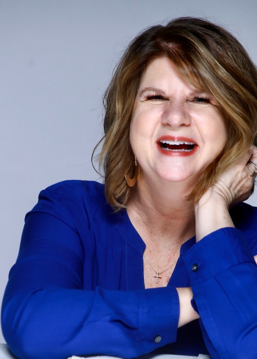 author photo of woman author laughing in blue shirt